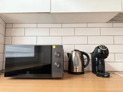 a microwave sitting on a counter with a tea kettle at Old Town Hideaway in Kaunas