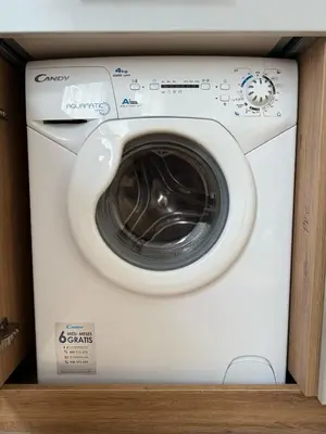 a white washing machine in a wooden cabinet at Old Town Hideaway in Kaunas