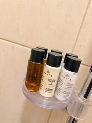 four bottles of moisturizers on a shelf in a bathroom at Old Town Hideaway in Kaunas