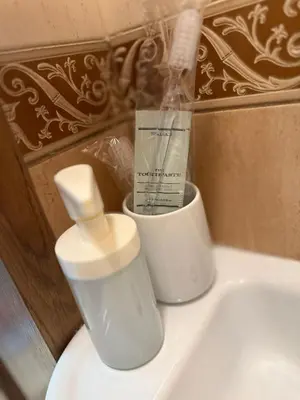 a white sink with a toothbrush and a bottle on it at Old Town Hideaway in Kaunas