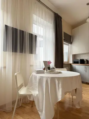 a white table with two white chairs and a kitchen at Old Town Hideaway in Kaunas
