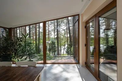 a house with a large glass door to a garden at Villa Emerald in Luokesos Sen
