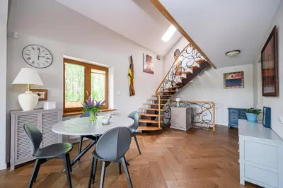 a dining room with a table and chairs and a staircase at Villa Emerald in Luokesos Sen