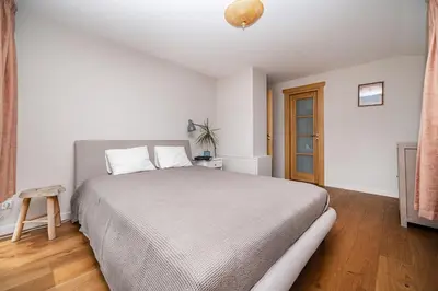 a bedroom with a large bed and a wooden floor at Villa Emerald in Luokesos Sen