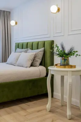 a green couch sitting next to a white table at Frida Luxury Apartments in Šiauliai