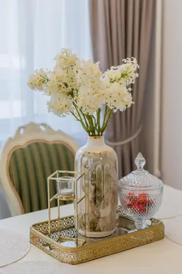 a vase with white flowers on a table at Frida Luxury Apartments in Šiauliai