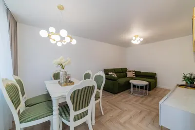 a living room with a table and chairs and a couch at Frida Luxury Apartments in Šiauliai