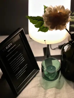 a table with a book and a vase with a flower at The Kliefs Vilnius - Virtual Check-In in Vilnius