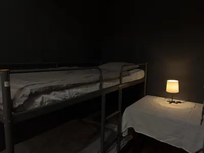 a dark room with two bunk beds and a lamp at The Kliefs Vilnius - Virtual Check-In in Vilnius
