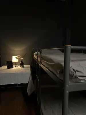 a dark room with two bunk beds and a lamp at The Kliefs Vilnius - Virtual Check-In in Vilnius