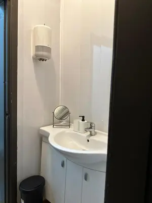 a white bathroom with a sink and a mirror at The Kliefs Vilnius - Virtual Check-In in Vilnius