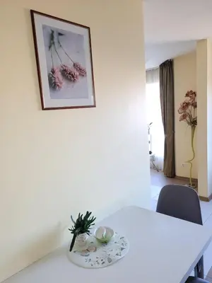 a white dining room table with a picture on the wall at Vaido apartamentai in Marijampolė