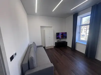 a living room with a couch and a tv at Modern Flat in Centre, Self Check-In, Free parking in Vilnius