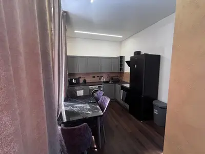 a small kitchen with a table and a refrigerator at Modern Flat in Centre, Self Check-In, Free parking in Vilnius