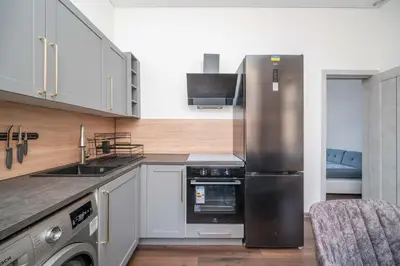 a kitchen with a stainless steel refrigerator and a sink at Modern flat , Self check in 24h, Netflix, parking in Vilnius