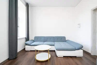 a living room with a blue couch and a table at Modern flat , Self check in 24h, Netflix, parking in Vilnius