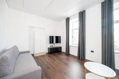 a living room with a couch and a tv at Modern flat , Self check in 24h, Netflix, parking in Vilnius