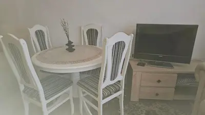 a white table with four chairs and a computer monitor at Butas su terasa Kauno centre pirmame aukšte Clinic in Kaunas