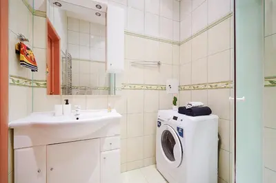 a bathroom with a washing machine and a sink at Jablonskis Apartment in Vilnius