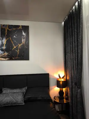 a bedroom with a bed and a lamp on a table at DOMINO apartamentai, SELF CHECK-IN in Panevėžys
