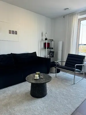 a living room with a black couch and a coffee table at Ozas Cozy Studio apartment in Vilnius