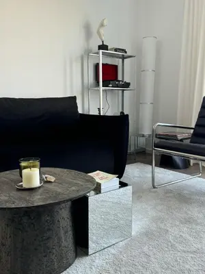a living room with a black couch and a table at Ozas Cozy Studio apartment in Vilnius