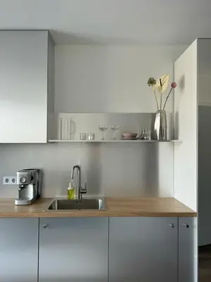 a kitchen with white cabinets and a sink at Ozas Cozy Studio apartment in Vilnius