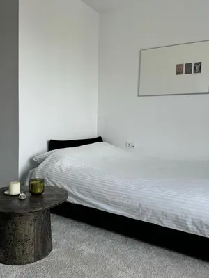 a bedroom with a bed and a table at Ozas Cozy Studio apartment in Vilnius