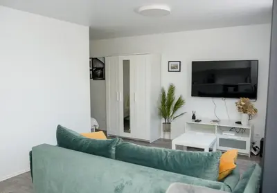 a living room with a blue couch and a tv at El Roi Home's in Vilnius