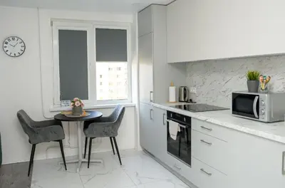 a kitchen with a table and chairs and a microwave at El Roi Home's in Vilnius