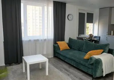 a living room with a green couch and a table at El Roi Home's in Vilnius
