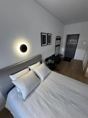 a bedroom with a large white bed with white pillows at New Airport Apartment in VNO