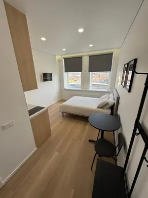 a bedroom with a bed and a desk and a table at New Airport Apartment in VNO