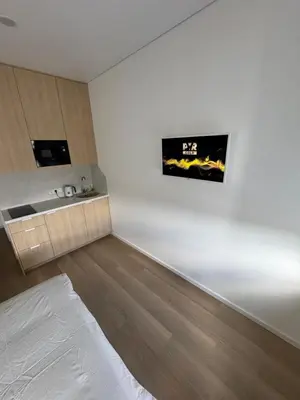 a room with white walls and wooden floors and a bed at New Airport Apartment in VNO