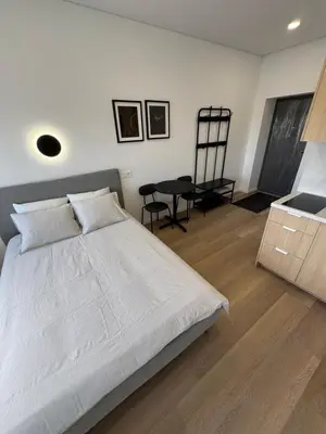a bedroom with a white bed and a chair at New Airport Apartment in VNO