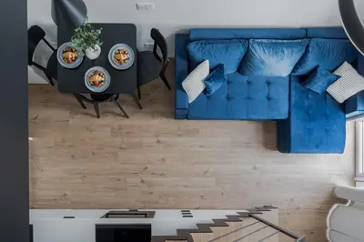 a living room with a blue couch and a table at 60 Loft in Vilnius