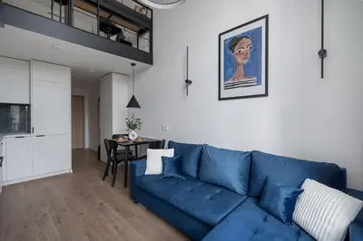 a living room with a blue couch and a table at 60 Loft in Vilnius