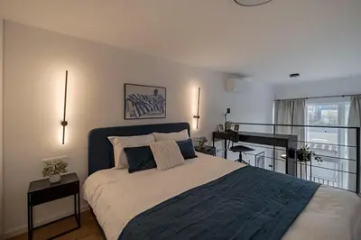 a bedroom with a large bed and a piano at 60 Loft in Vilnius