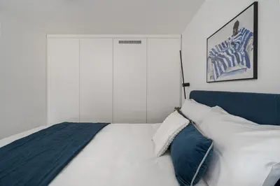 a bedroom with a white bed with a blue headboard at 60 Loft in Vilnius