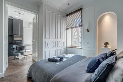 a bedroom with a bed with blue pillows on it at New! Luxury Old town apartment in Vilnius