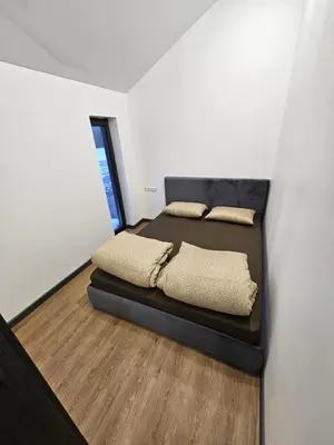 a bedroom with a bed with two pillows on it at Pasienio Krantas in Velūnai