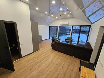 a living room with a couch and chairs and windows at Pasienio Krantas in Velūnai