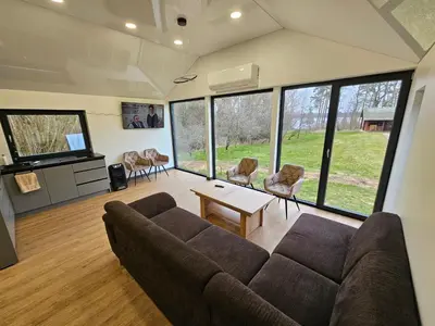 a living room with a couch and a table at Pasienio Krantas in Velūnai