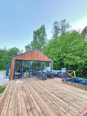 a large wooden deck with couches on it at Pasienio Krantas in Velūnai