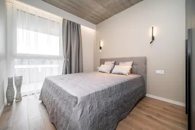 a bedroom with a bed and a large window at Luxury apartment near downtown in Vilnius
