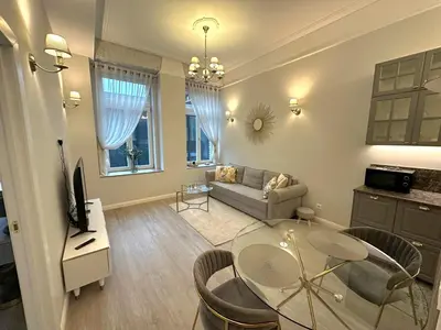 a living room with a glass table and a couch at Apartamentai Bazilijonai in Vilnius