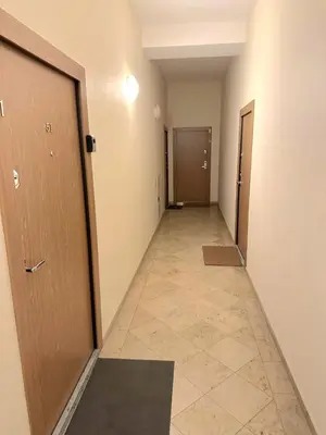 an empty hallway with two doors and a tile floor at Apartamentai Bazilijonai in Vilnius