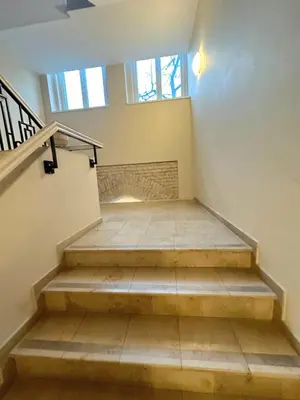 an empty room with stairs and a window at Apartamentai Bazilijonai in Vilnius