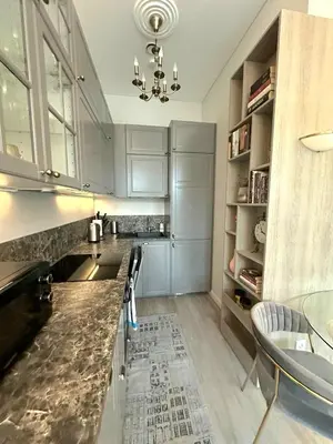 a kitchen with stainless steel appliances and a chandelier at Apartamentai Bazilijonai in Vilnius