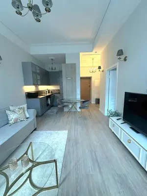 a large living room with a couch and a kitchen at Apartamentai Bazilijonai in Vilnius